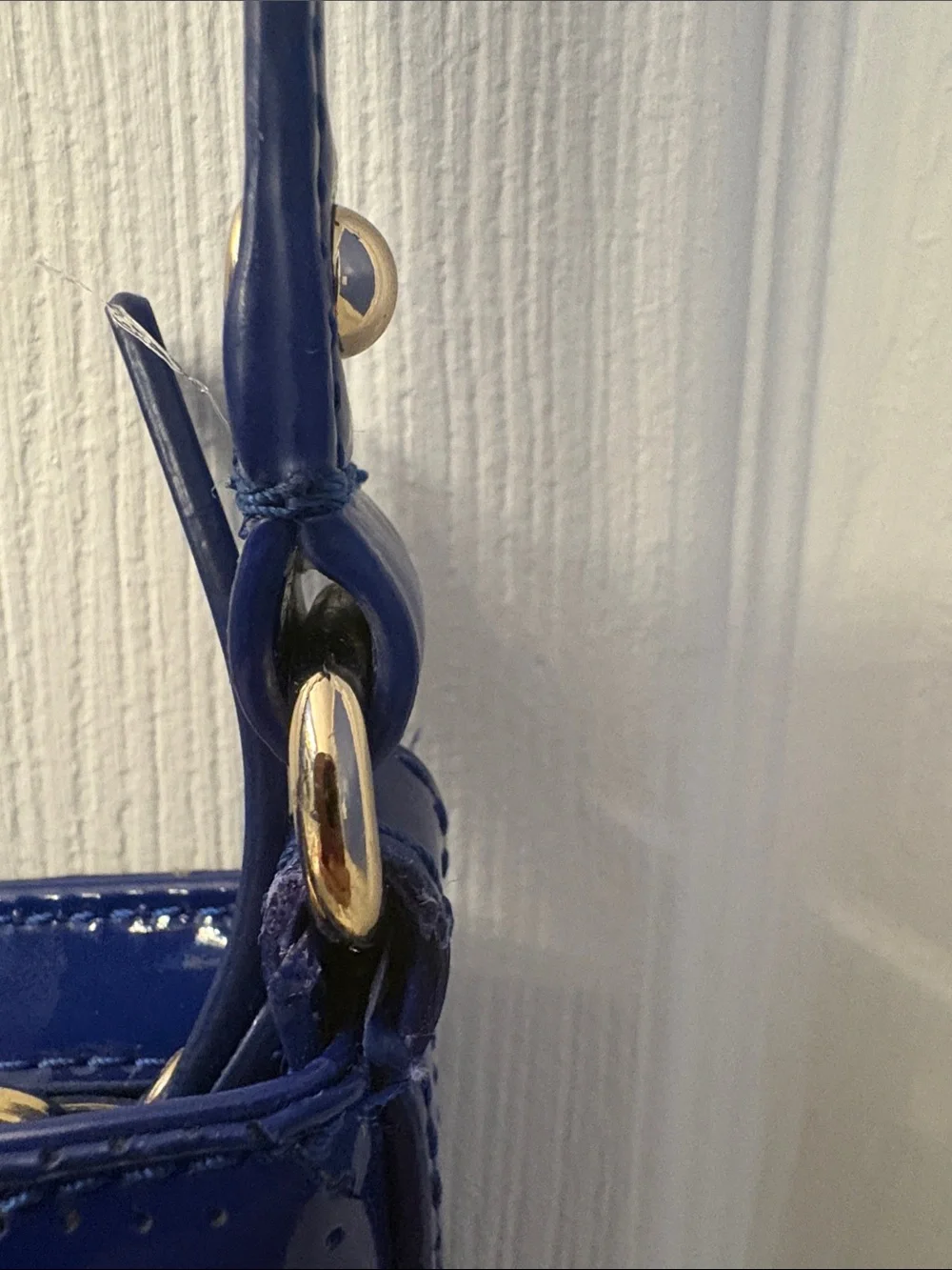 Kate Spade heart perforated patent leather crossbody in cobalt blue.